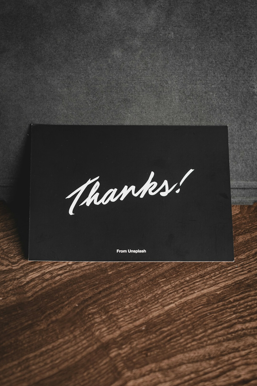 Hand writing notes on paper at a wooden desk